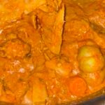 Traditional Malian peanut butter stew with meat and vegetables in a cooking pot